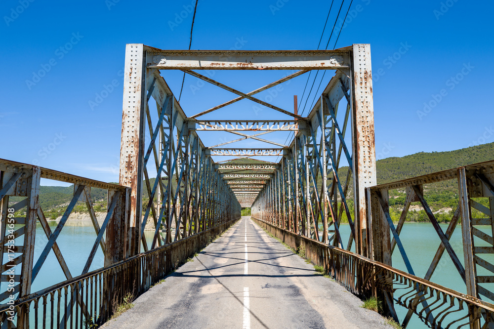 Fototapeta premium This landscape photo was taken in Europe, Spain, Aragon, Zaragoza, in summer. It shows the bridge over the lake of Las Peñas, under the Sun.