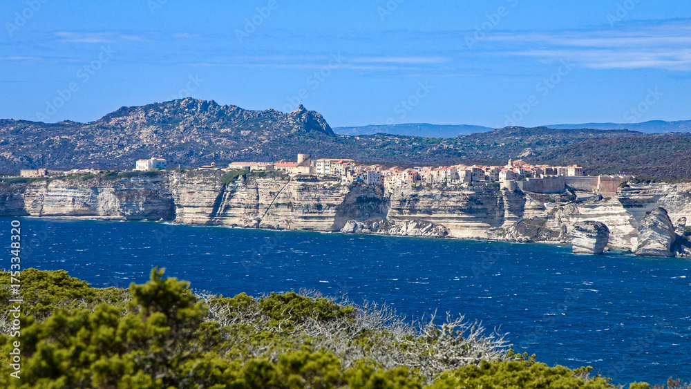 Fototapeta premium view of the medieval town of Bonifacio with its white limestone coastline and rough, deep blue turquoise sea in sunshine and blue skies