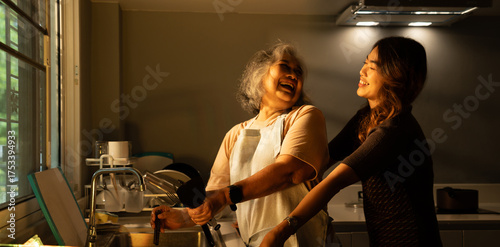 In the kitchen at home, a senior adult and their daughter cook together, sharing love and care. Their closeness strengthens their family relationship, creating lasting memories while embracing health