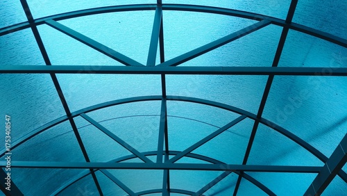 Transparent greenhouse roof or ceiling made of metallic frames and blue polycarbonate panels or sheets. Closeup bottom view. sunlight or daylight protection exterior roofing business concept.