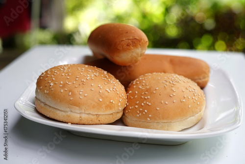 Hamburger and hot dog buns on white plate isolated on white background.