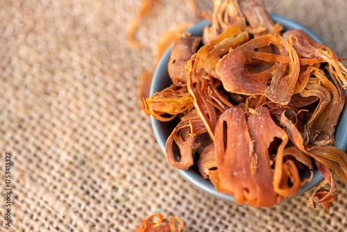 Foto Dried mace spice, the lacy aril of the nutmeg fruit, in a bowl on a burlap backg