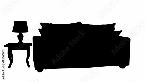 Silhouette of a sofa with pillows next to a bedside table with a lamp casting a dark shadow on the wall