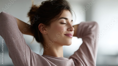 Smiling female professional taking a short break to loosen up muscles, enjoying a moment of calm and achievement at work. Healthy lifestyle and productivity combined