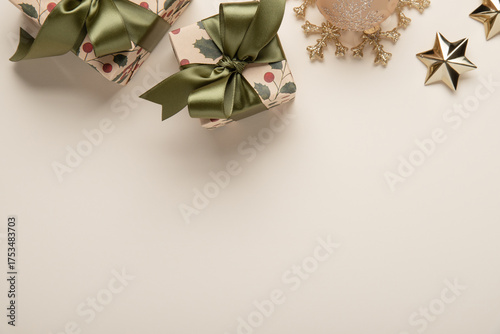 Merry Christmas and Happy Holidays greeting card, frame, banner. New Year. Christmas ornaments and gifts, presents on light beige background top view. Winter xmas holiday festive theme.	

