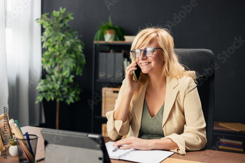 Businesswoman talking on phone working at office desk