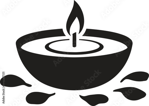 Silhouette of a burning candle in a bowl with petals