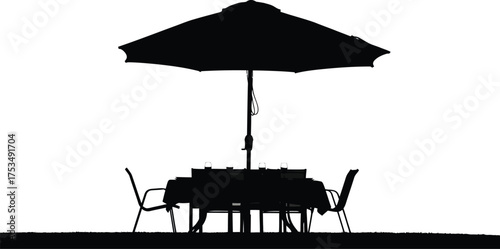 Dark silhouette of patio umbrella, table, chairs