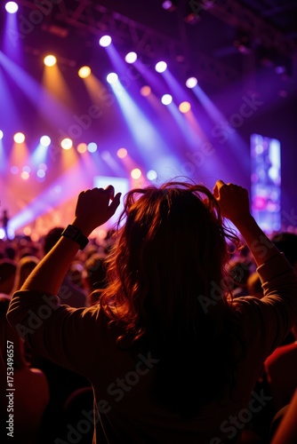 a person in front of a stage with their hands up