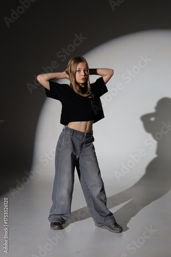 Young caucasian female posing in studio with shadows and contrast lighting