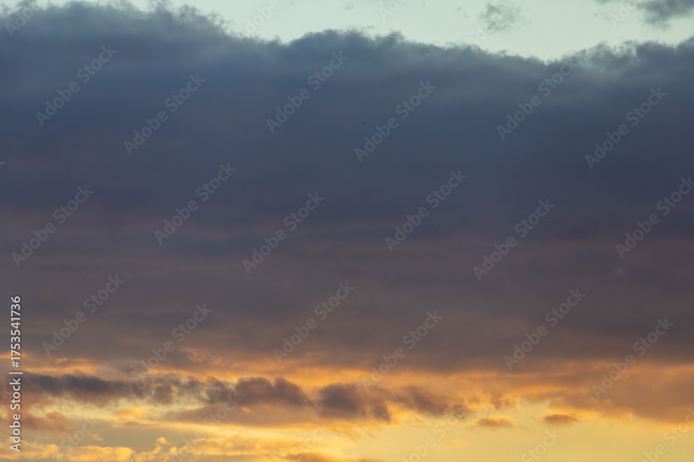 Obraz premium Dramatic Sunset Sky with Golden and Dark Clouds