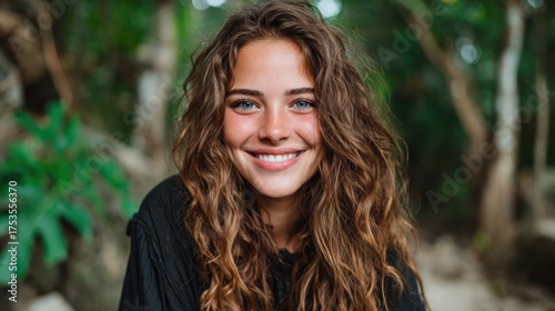 A close-up portrait of a young woman smiling brightly amidst lush greenery, showcasing natural beauty and the joyful essence of life surrounded by nature's splendor.