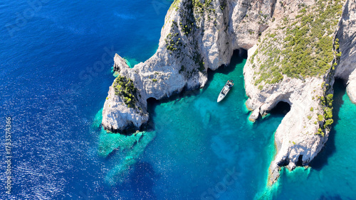 Obraz na plátně Aerial drone top down photo of inflatable rib boat anchored in paradise volcanic