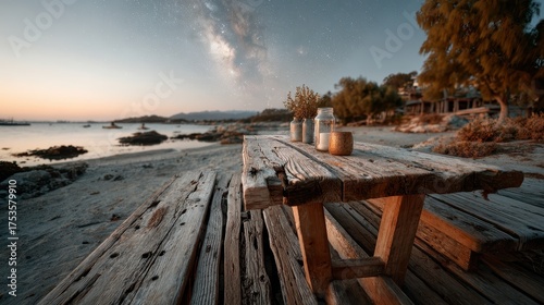 A serene beach landscape at sunset, featuring a rustic wooden table adorned with jars and flowers, set against a starry night sky reflecting calmness and beauty.