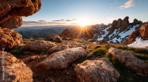 A breathtaking view of rugged mountains illuminated by the setting sun, showcasing the vibrant colors of nature and the vast landscape during twilight hours.