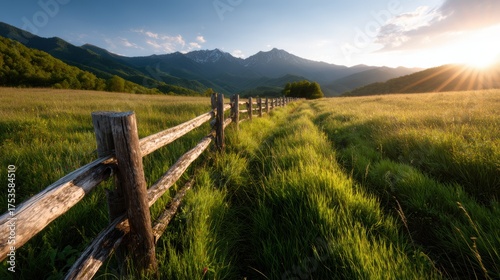 A picturesque view of a mountain pathway framed by rustic wooden fencing, evoking a sense of adventure and exploration within the lush green scenery and stunning landscape.