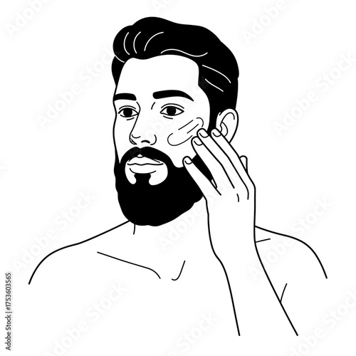 Young man applying skincare product to face with thoughtful expression  