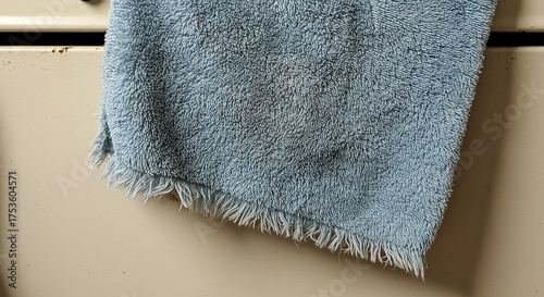 Close up of a light blue towel hanging from a kitchen appliance