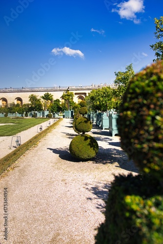 Slika na platnu Manicured gardens and ornamental hedges adorn the lavish grounds of a grand, historical palace under a vibrant blue sky