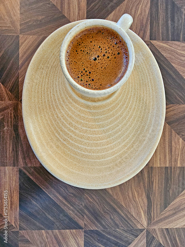 Cup of coffee on a wooden table. View from above.