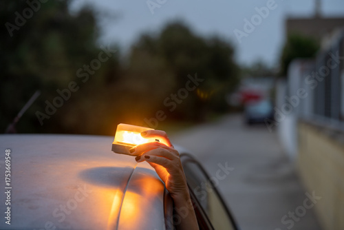 v16 Woman placing emergency beacon light on broken down car