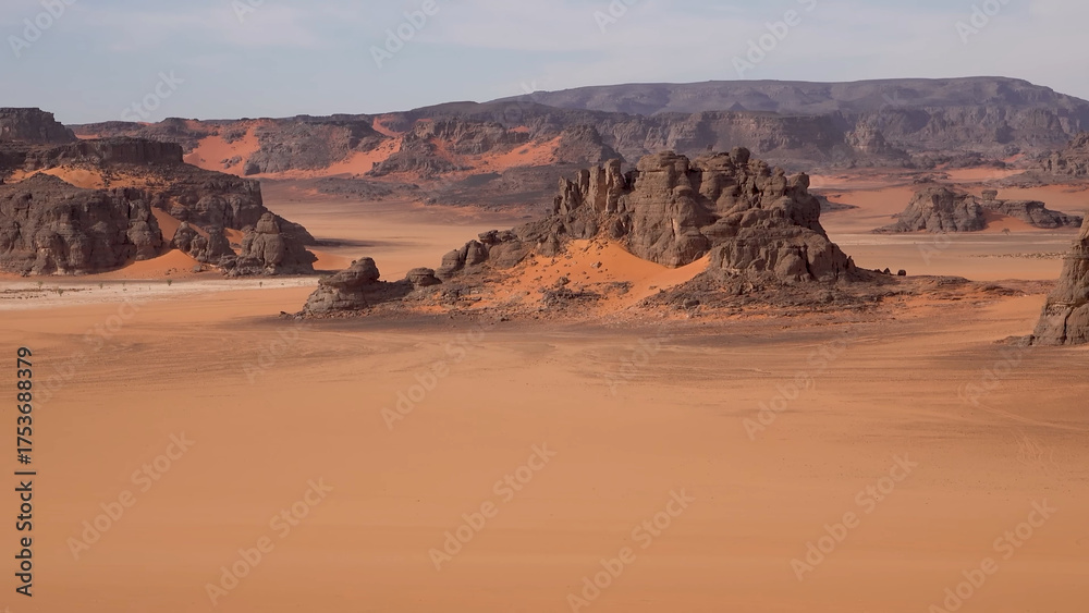 Naklejka premium A trip to Sahara desert in Algeria. Beautiful african travel photo. Sandy landscapes, mountains, rocks, dunes, and nature. Summer vacation in arab country.