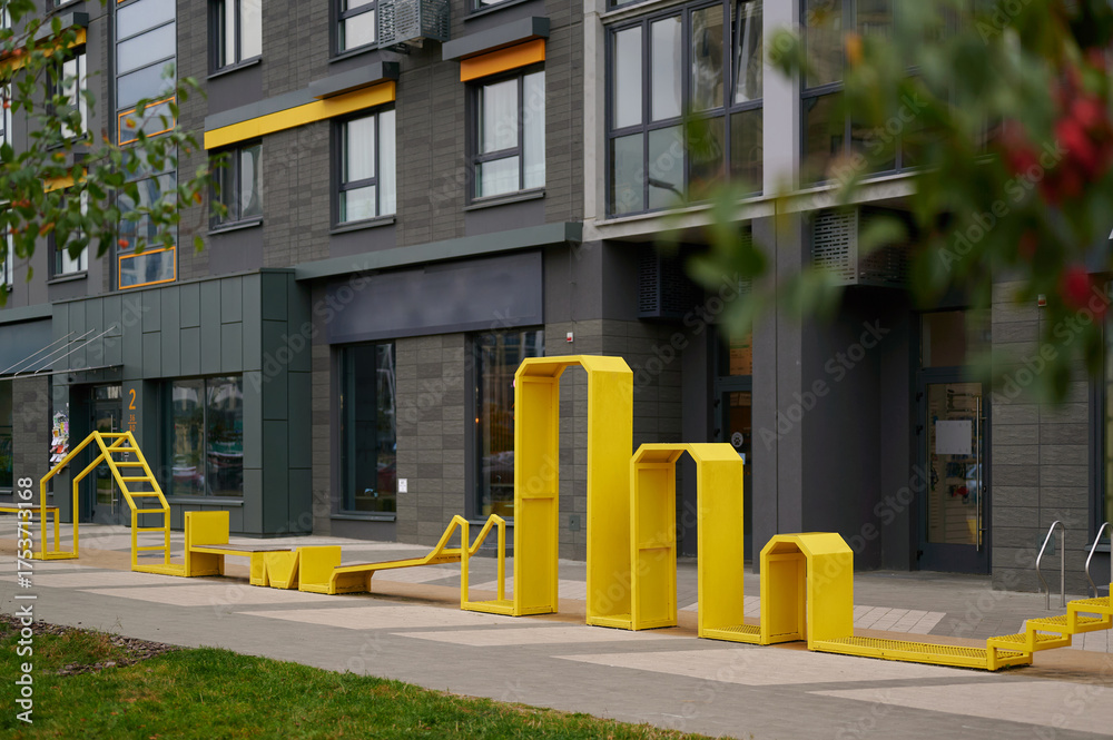 Naklejka premium yellow outdoor structure in vibrant urban setting, modern architecture background, creative design inviting exploration. perfect for cityscape-themed projects, playful architectural studies