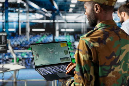 Foto Black military IT expert in server hub using AI tools to oversee battlefield surveillance to develop warfare tactics