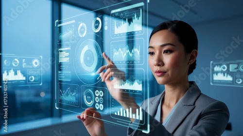 Asian businesswoman using a futuristic holographic touch screen. Professional analyzing data charts and graphs on a virtual interface. Business intelligence and innovation concept