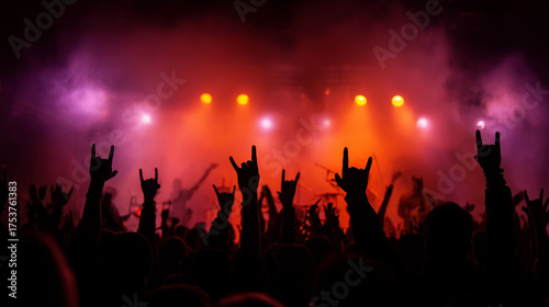 A crowd of excited fans at a live rock concert, silhouettes raising hands with rock gestures under colorful stage lights, symbolizing passion, music, and energy.