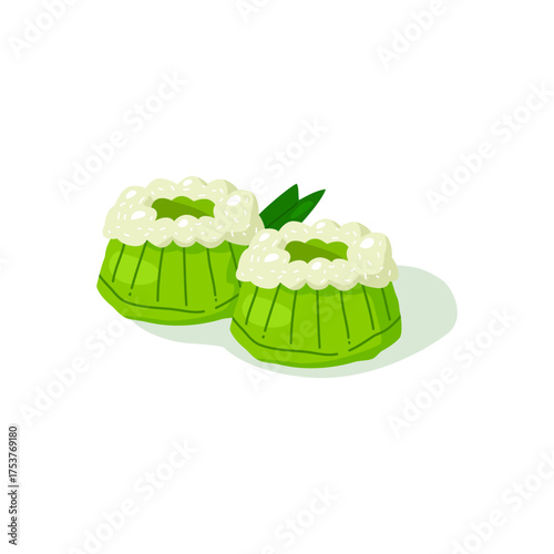 Indonesian traditional cake kue putu with grated coconut on top and pandan leaf behind