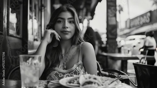 A woman enjoys her meal amidst the din of a lively eatery.