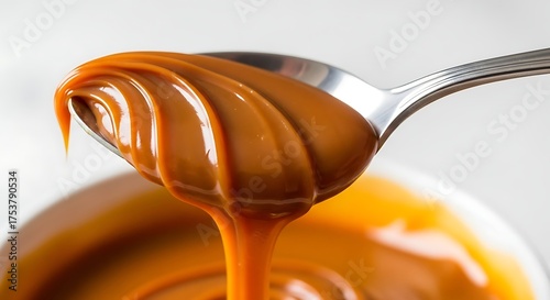 spoon lifting thick dulce de leche dripping slowly
