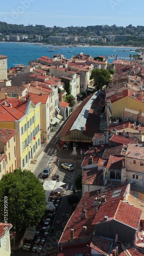 Aerial drone view of Antibes Old Town rooftops with Chateau Grimaldi and church towers facing the Mediterranean Sea. Vertical