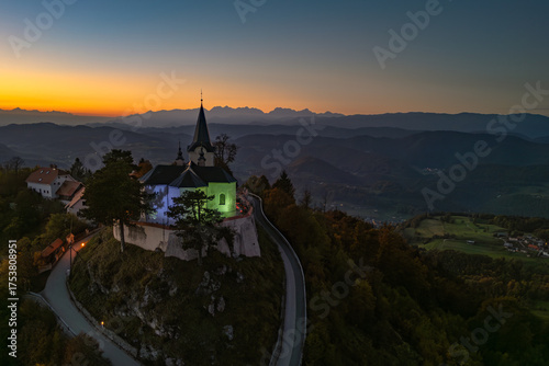 Evening view of the Church of the Birth of Mary atop Zasavska Sveta Gora, a historic pilgrimage site with Gothic and Baroque architecture.