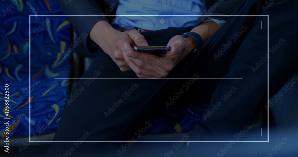 Obraz premium Checking smartphone male commuter wearing blazer and watch in train cabin with patterned upholstery