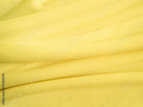 Yellow fabric background. Wavy cloth texture