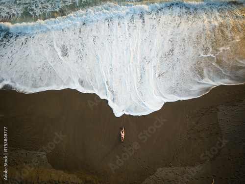 Vista aérea con dron de una mujer contemplando la orilla del mar
