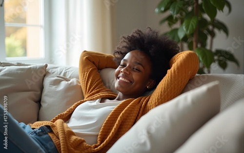 Happy afro american woman relaxing on the sofa at home - Smiling girl enjoying day off lying on the couch - Healthy life style, good vibes people and new home concept. High quality