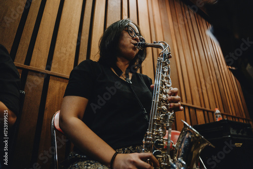 Female saxophonist playing saxophone in recording studio