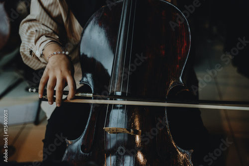 Close up detail of musician playing cello in orchestra rehearsal