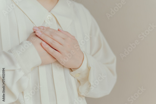 胸に手を当てる女性の手