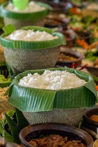 Traditional Indonesian white rice served in bamboo woven bowl lined with banana leaf, authentic Asian cuisine background