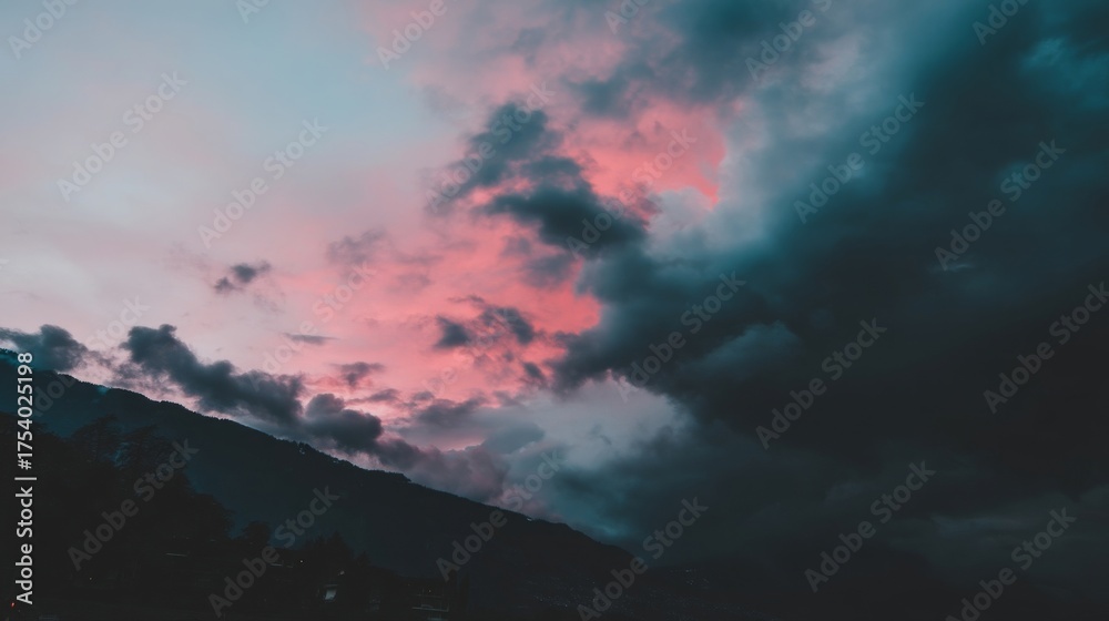 Fototapeta premium Dramatic sunrise or sunset landscape with pink purple blue sky reflecting on dense clouds rolling hills silhouette moody