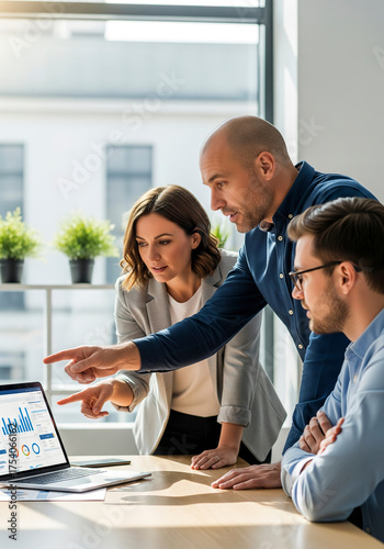 Team discussion around laptop during office meeting