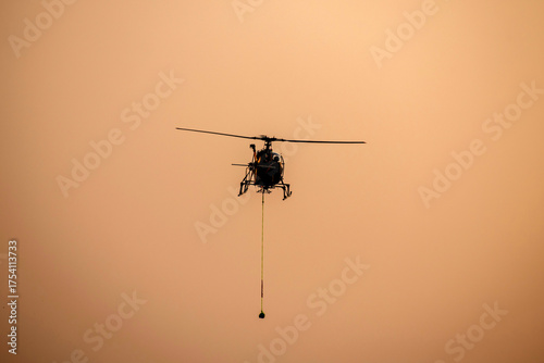 Silhouette Helicopter rescue against isolated mid-air on evening sky