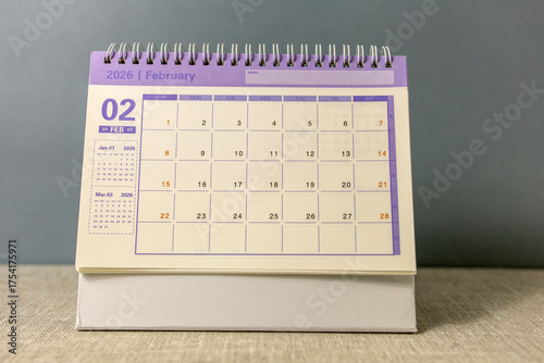 Desk calendar for February 2026 on a gray background.