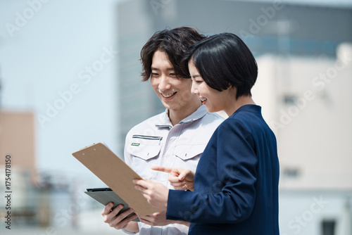 Foto 建設現場でタブレットを見る現場監督とビジネスウーマン