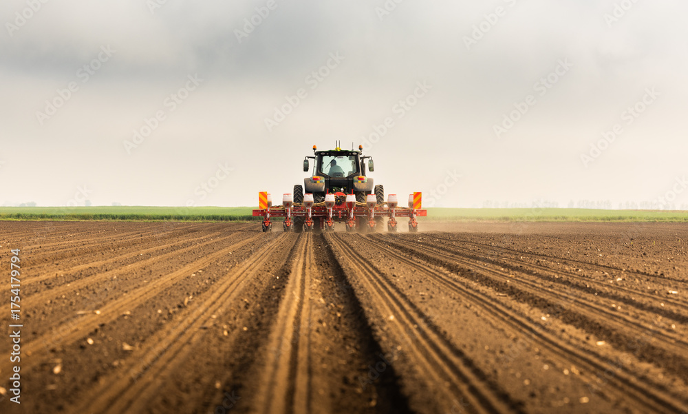 Fototapeta premium Tractor and seeder for sowing corn