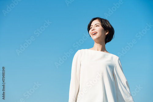 青空で青空を見ある若い女性